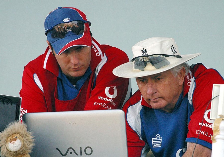 Two cricket coaches looking at a laptop screen