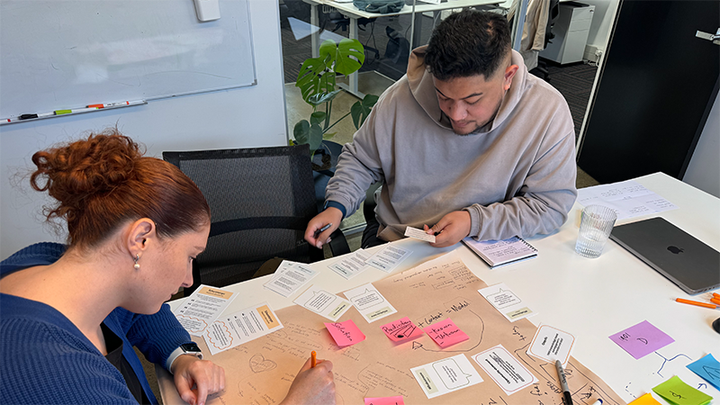 Workshop participant sharing thoughts with facilitator at a table